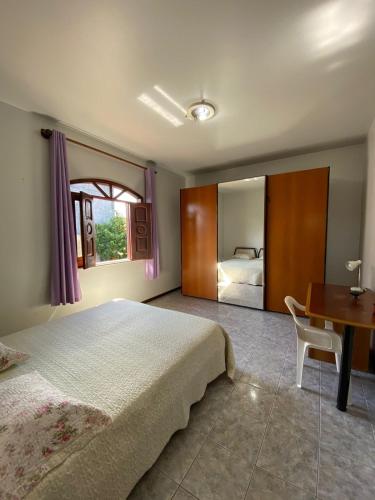 a bedroom with a bed and a table and a desk at Casa Raiz in Valença