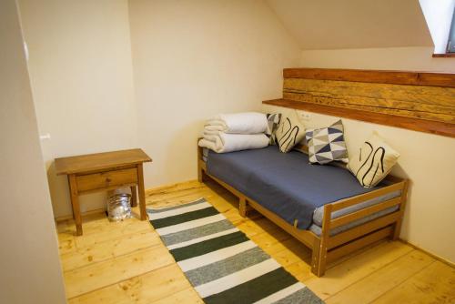 a small bedroom with a bed and a table at Válaszút Fogadó in Păuleni-Ciuc