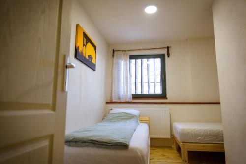 a small room with two beds and a window at Válaszút Fogadó in Păuleni-Ciuc