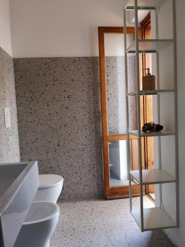 a bathroom with two toilets and a mirror at Il Porticato - Affittacamere in Paola