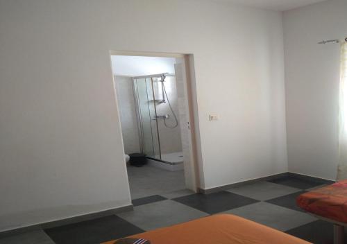a bathroom with a shower and a door to a room at Kolina D´Sol in Ponta do Sol