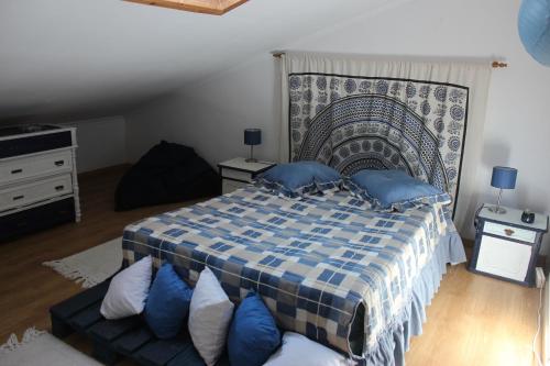 een slaapkamer met een groot bed met blauwe kussens bij AL- Quinta dos Carvalhais in Rio Maior