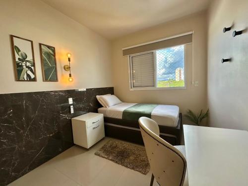 Habitación pequeña con cama y mesa en PALMAS EXPERIENCE - APARTAMENTO SUBLIME, vista incrível, em frente ao shopping en Palmas
