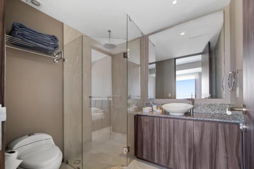 La salle de bains est pourvue d'une douche, de toilettes et d'un lavabo. dans l'établissement Beachfront Bliss: Luxurious 4-Bedroom Apartment, à Acapulco