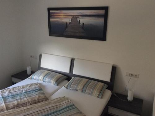 ein Schlafzimmer mit einem Bett und einem Bild an der Wand in der Unterkunft Ferienwohnung Bodenseezauber in Langenargen