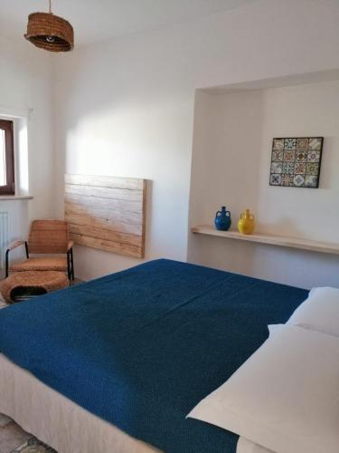a bedroom with a bed with a blue blanket at Intornoalnoce in Cisternino