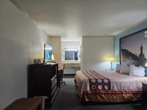 Habitación de hotel con cama y TV de pantalla plana. en budgetel Inn & Suites en Moody