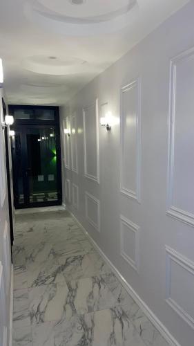 a room with a hallway with white walls and a door at Suna' a Home Bonapriso in Douala