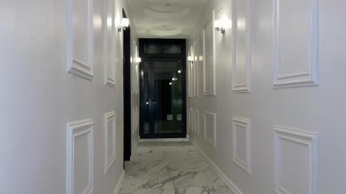 a hallway with white walls and a black door at Suna' a Home Bonapriso in Douala