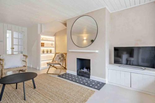 a living room with a fireplace and a mirror at sea side cottage near beach in West Wittering