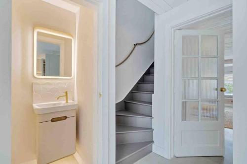 a bathroom with a sink and a staircase at sea side cottage near beach in West Wittering