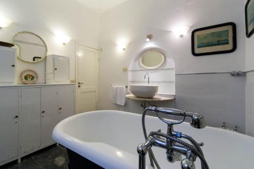 Baño blanco con bañera y lavamanos en The best view in the world!, en Zoagli
