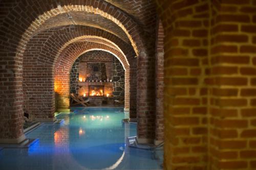 an indoor swimming pool with a brick wall at Hotel Zamek Ryn in Ryn
