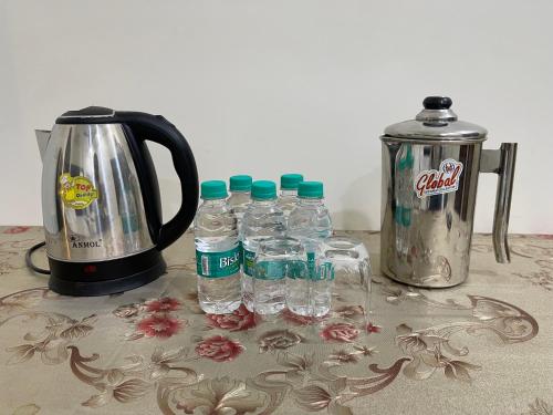 a group of bottles of water next to a coffee maker at Homestay Comforts 500m from Amritsar Airport in Amritsar