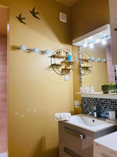 une salle de bain avec un lavabo et un miroir dans l'établissement L'ATHENA, à Dieppe