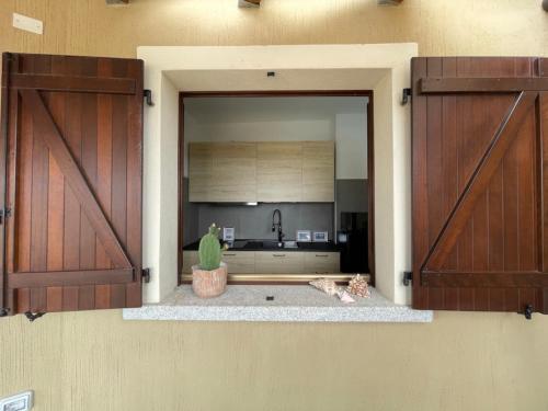 a kitchen with two open doors with a cactus at bella vista Villasimius in Villasimius