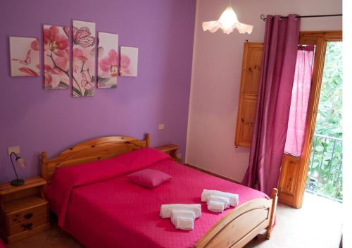 a bedroom with a red bed with two towels on it at Hotel Il Cortile in Custonaci