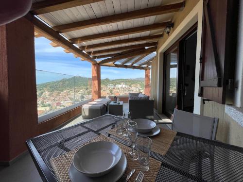 una sala da pranzo con tavolo e vista di bella vista Villasimius a Villasimius