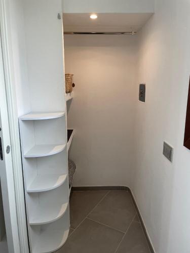 a closet with white shelves in a room at bella vista Villasimius in Villasimius