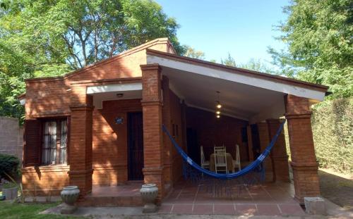 a small brick house with a blue rope around it at Casa de campo El Zoki in Villa Anizacate