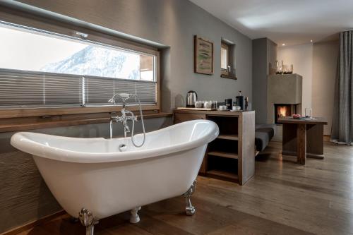 a bath tub in a bathroom with a window at Das.Goldberg in Bad Hofgastein