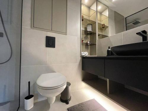 a bathroom with a white toilet and a sink at New Chic & Minimal Old Town Flat in Kuressaare
