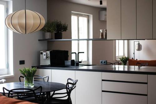 a kitchen with a table with chairs and a counter top at New Chic & Minimal Old Town Flat in Kuressaare