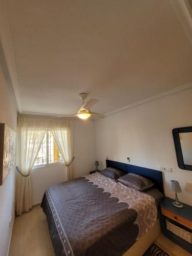 um quarto com uma cama grande e uma janela em Palmerita 5 em Mar de Cristal