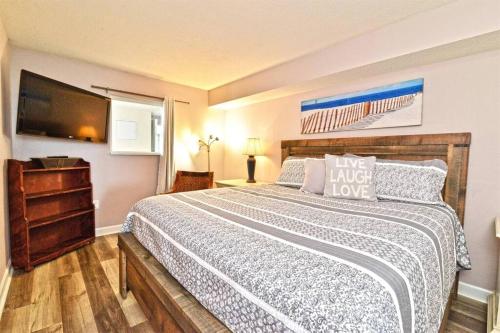 ein Schlafzimmer mit einem großen Bett und einem TV in der Unterkunft Oceanfront with Lazy River and Huge Pool Oasis in Myrtle Beach
