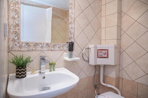 a bathroom with a sink and a mirror at Hotel Pithari in Agia Triada