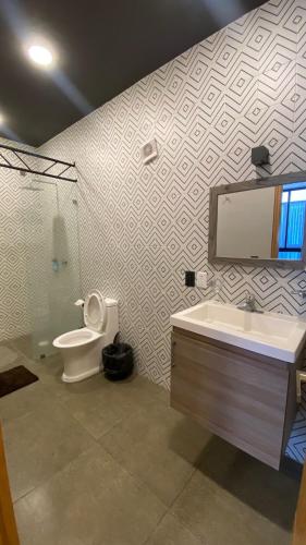 a bathroom with a toilet and a sink and a mirror at REVU 519 in Tepic