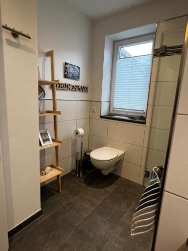 a bathroom with a toilet and a window at Ferienwohnung am Bach 