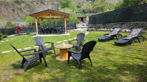 a group of chairs and a table and a gazebo at Casa Ramus Valle Camonica a 30 km dal Passo Tonale in Edolo