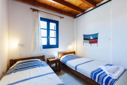 two beds in a room with a window at Thalassitis Coastal Apartments in Perivolos