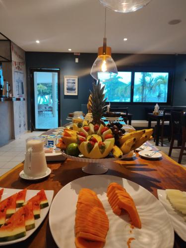 a table topped with plates of fish and fruit at Kastel Jampa Hotel in João Pessoa