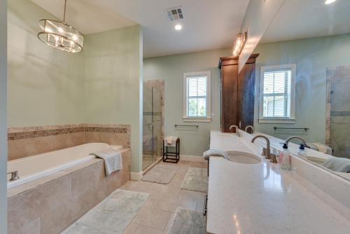 a bathroom with two sinks and a tub and a shower at Spacious Lake Charles Craftsman - Pet Friendly! in Lake Charles