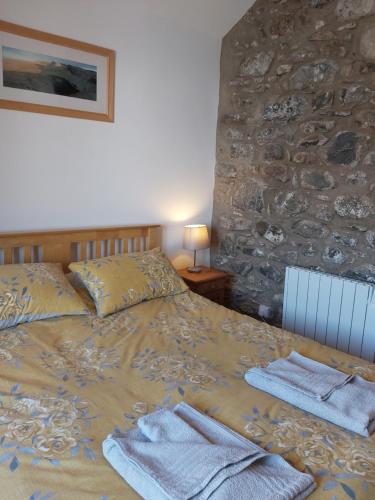 a bedroom with a bed with towels on it at Family stay by the beach in Chwilog