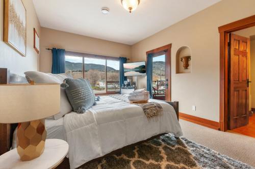 a bedroom with a bed and a large window at Casa Grande Inn & Suites in Penticton