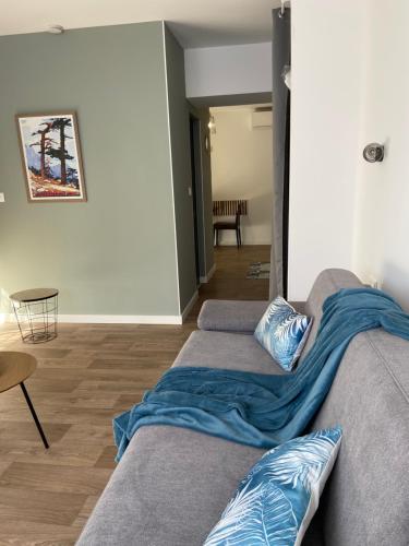 - un salon avec un canapé et une couverture dans l'établissement Résidence City Suites Ajaccio, à Ajaccio