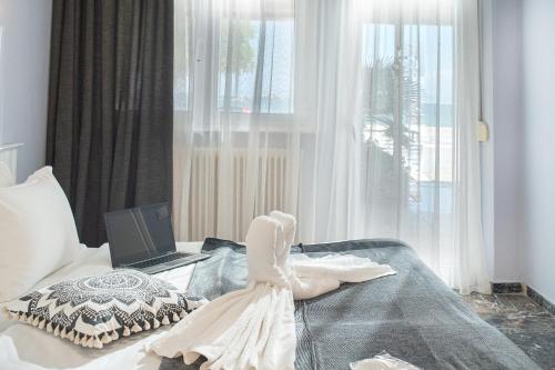 a bedroom with a bed with a laptop on it at Hotel Pithari in Agia Triada