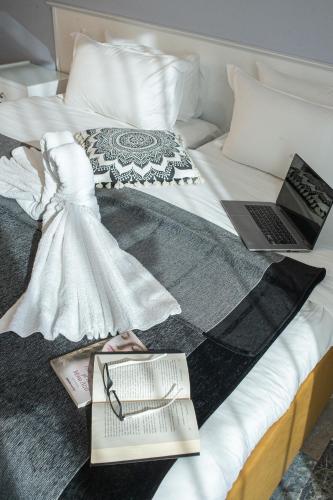 a bed with two laptops and a dress on it at Hotel Pithari in Agia Triada