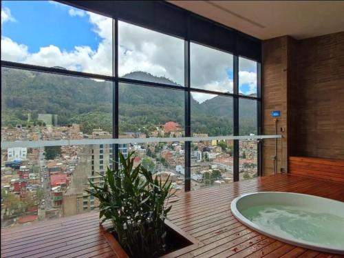 a bathroom with a tub and a large window at Wohnung Queens Deluxe in Bogotá