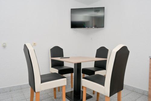 a table and chairs with a television on a wall at Apart Cobras Jajce in Jajce