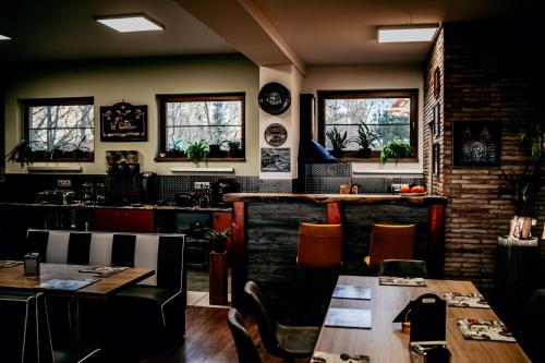 a restaurant with tables and chairs and windows at Jantarvia Car Museum , Pasja i Wypoczynek Noclegi z Klimatem in Jantar