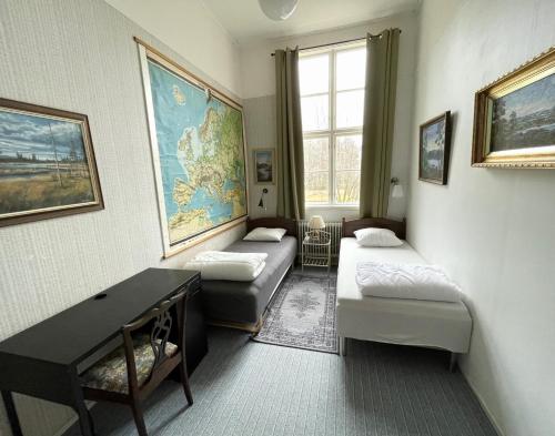 a room with two couches and a desk and a map at Tivedens Hostel-Vandrarhem in Karlsborg
