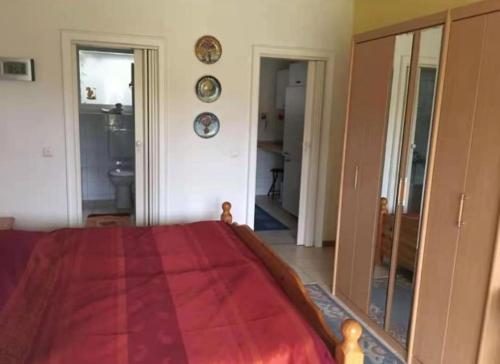 een slaapkamer met een rood bed en een spiegel bij FeWo-Mitten In Schwarzwald in Titisee-Neustadt