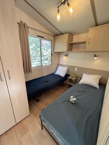 a bedroom with two beds and a window in it at Les mobil homes de Naka , camping le NOVELA in Port-la-Nouvelle