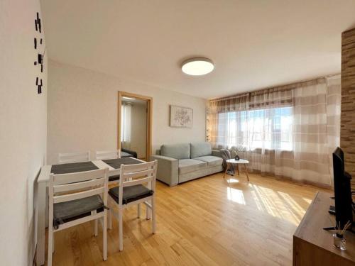 a living room with a table and a couch at New Apartment with a View in the Town Center in Narva