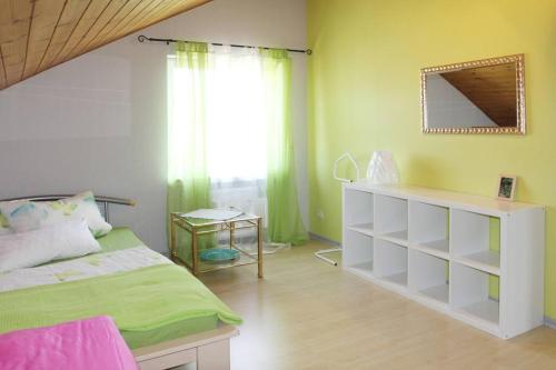 - une chambre avec un lit vert et blanc et une fenêtre dans l'établissement Ferienwohnung Kirschenlohr, à Ober-Abtsteinach
