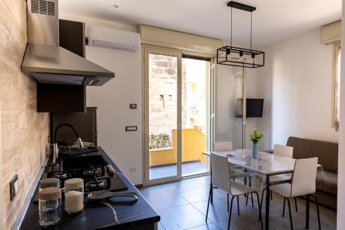 a kitchen with a stove and a table with chairs at Atrepassidalmare in Marina di Ragusa